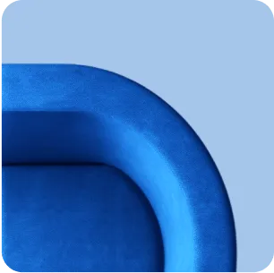 Close-up of a curved blue sofa corner against a light blue background.