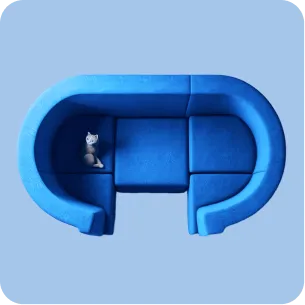 Top view of a blue curved sectional sofa with a small gray and white cat sitting on it.