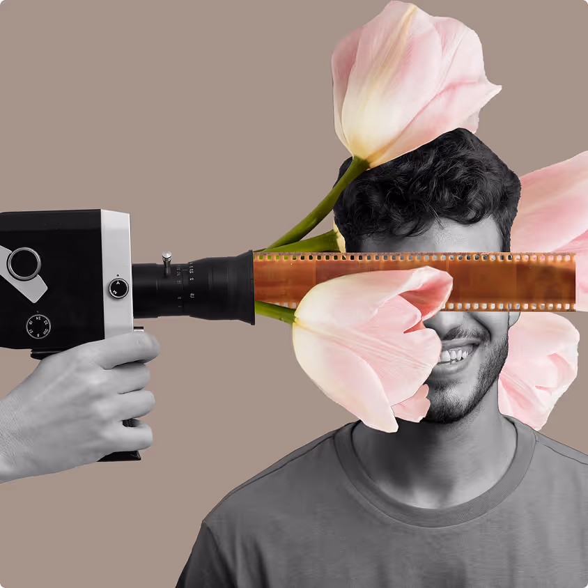 Black and white photo of a smiling man with pink tulip flowers and a strip of film across his eyes, and a hand holding a vintage video camera pointed at him.