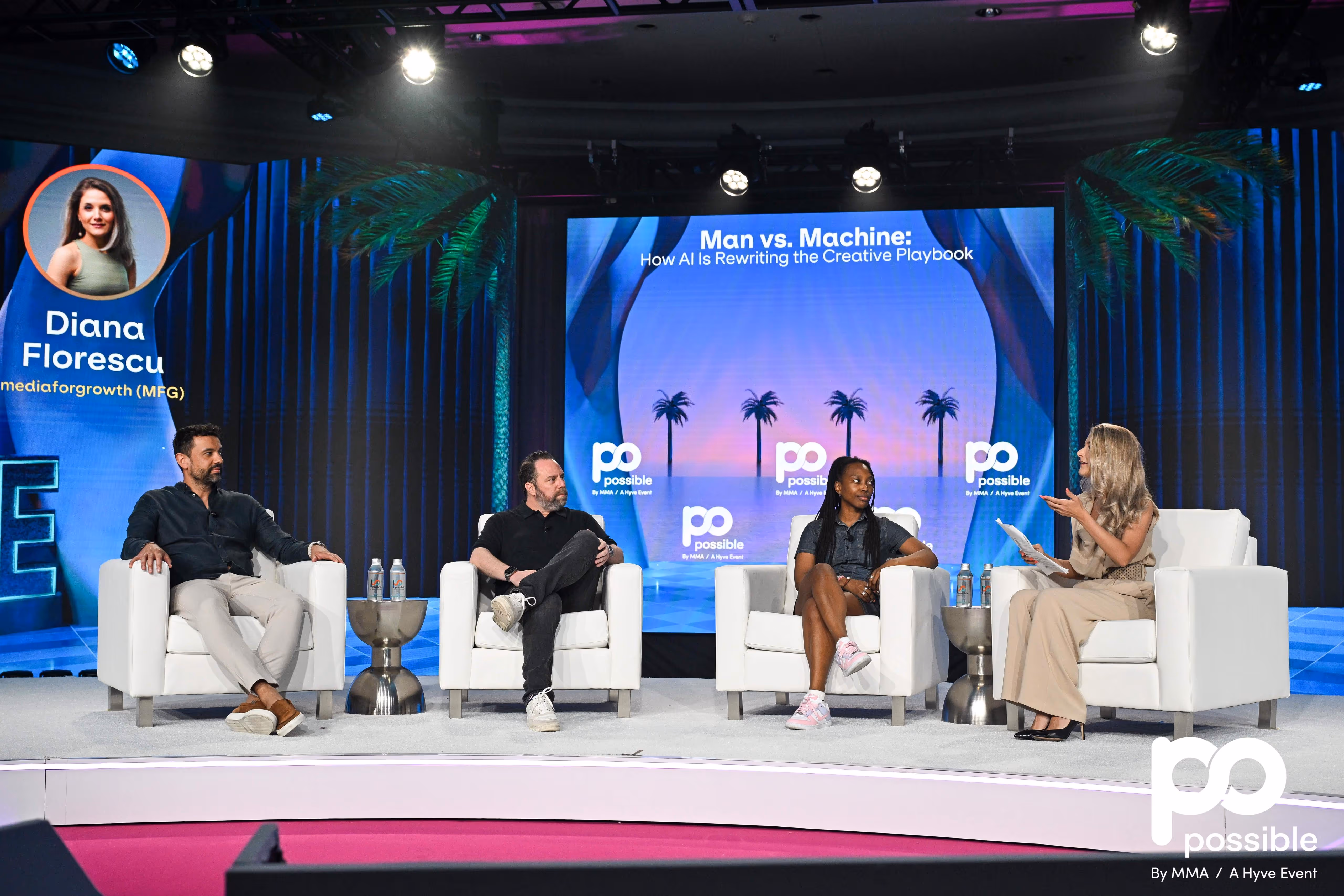 Four panelists seated on white armchairs on a stage with a large screen behind displaying 'Man vs. Machine: How AI Is Rewriting the Creative Playbook'.