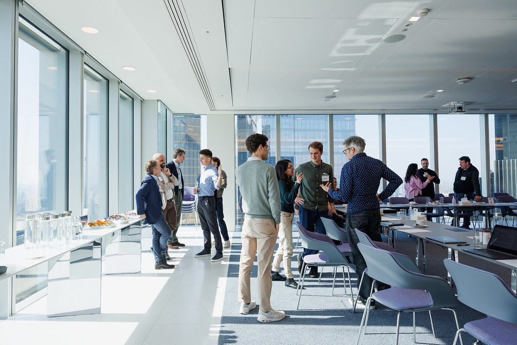 People networking and smiling during a social event or conference gathering indoors.