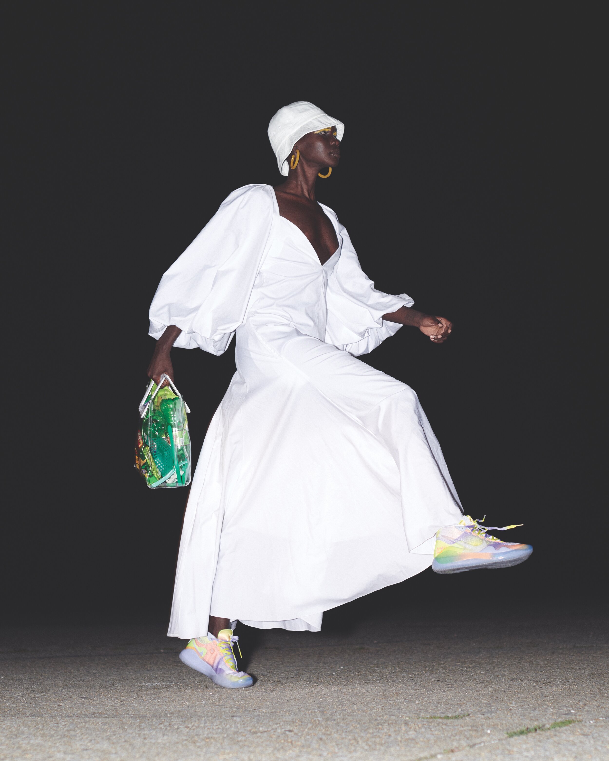 KHAITE dress, NIKE shoes, HAVE A GOOD TIME hat, MACHETE earrings, and stylist’s own bag.