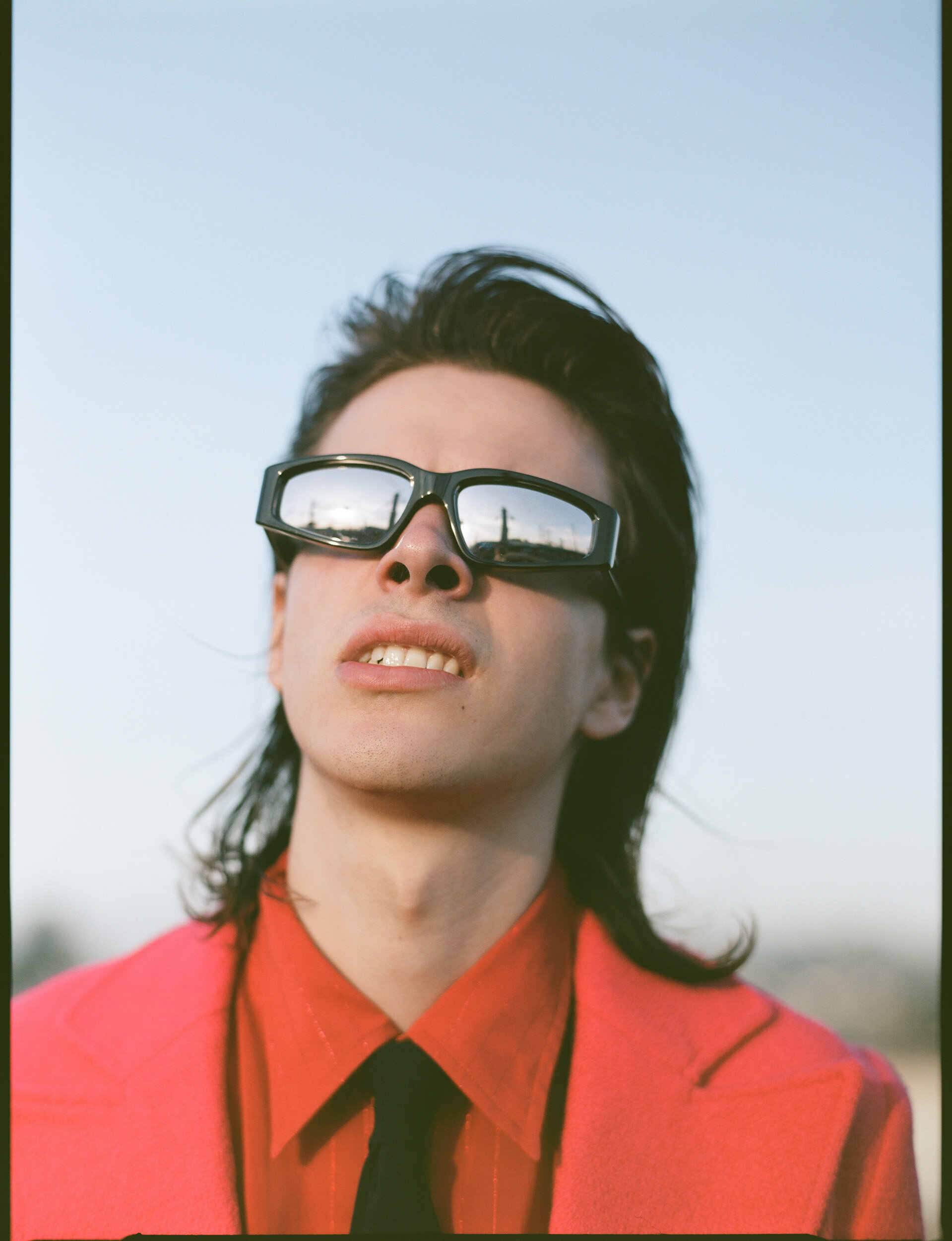 GUCCI blazer, shirt, tie, and sunglasses.