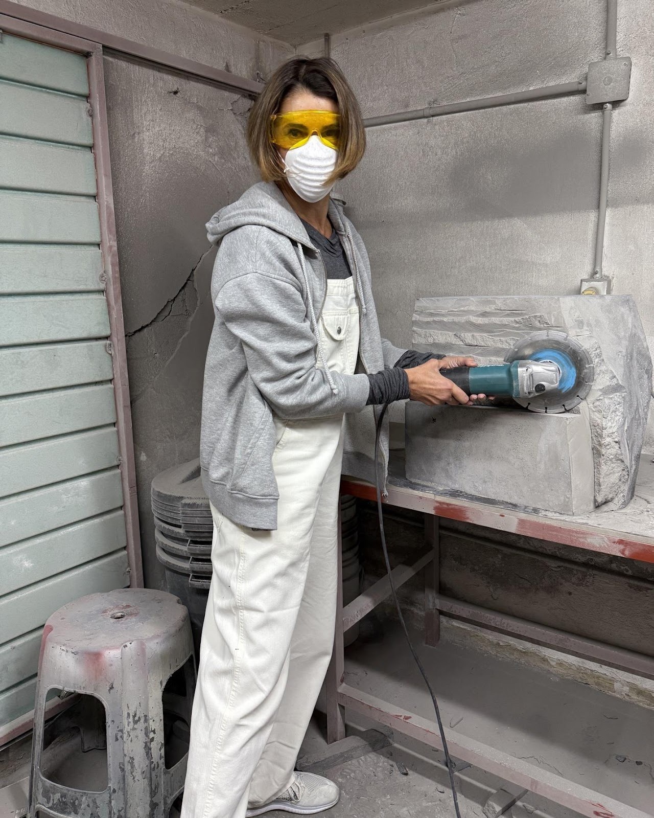 A person wearing goggles and a mask using a grinderAI-generated content may be incorrect.