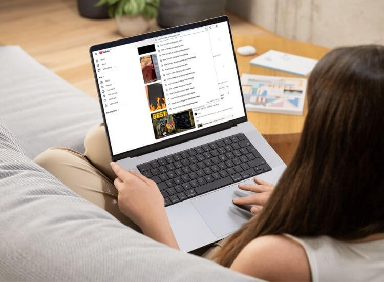 A laptop displaying YouTube search suggestions and a keyword research tool interface