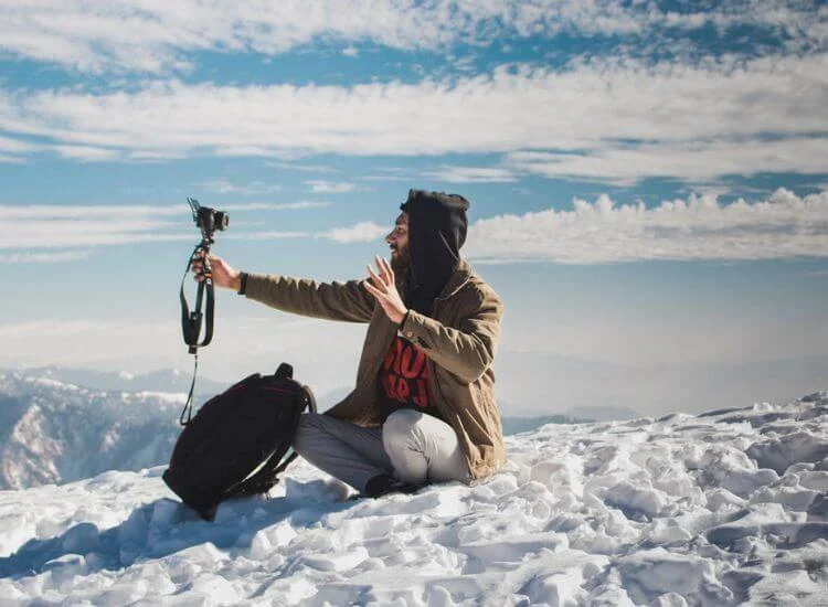 travel vlogger filming content in a snow mountain