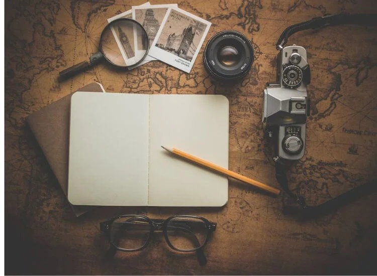 planning a travel vlog with a map and camera