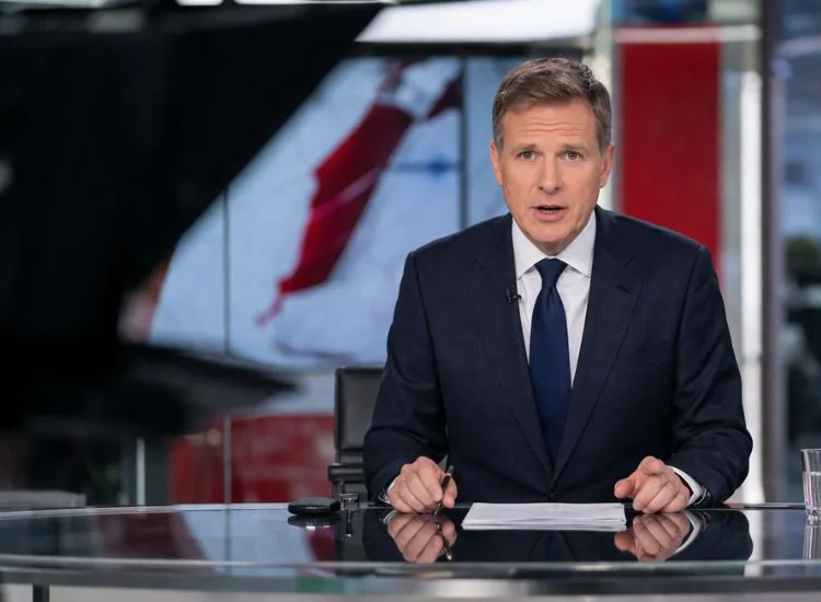 broadcast journalist reading from an autocue during a live news program in a television studio