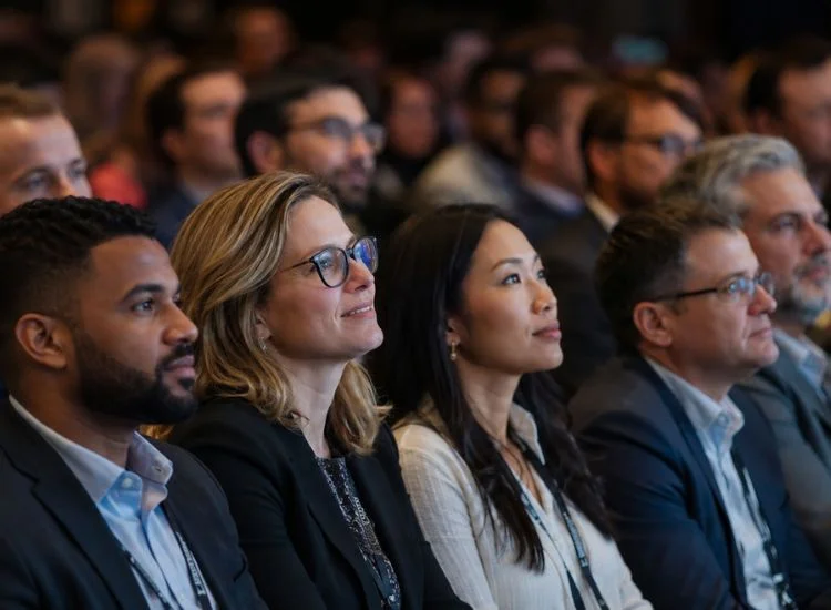 (Engaged audience leaning forward during a speech opening, showing the effect of a strong speech hook