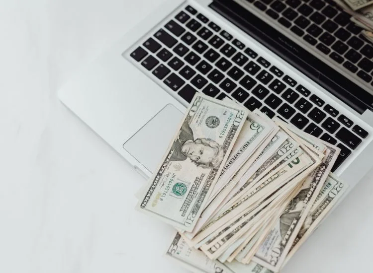 dollar paper bills placed on top of a laptop - YouTube monetization