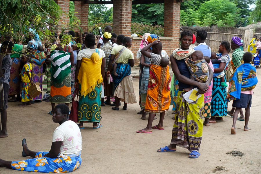 Bunt gekleidete Menschen in Afrika, die Babies auf dem Arm tragen