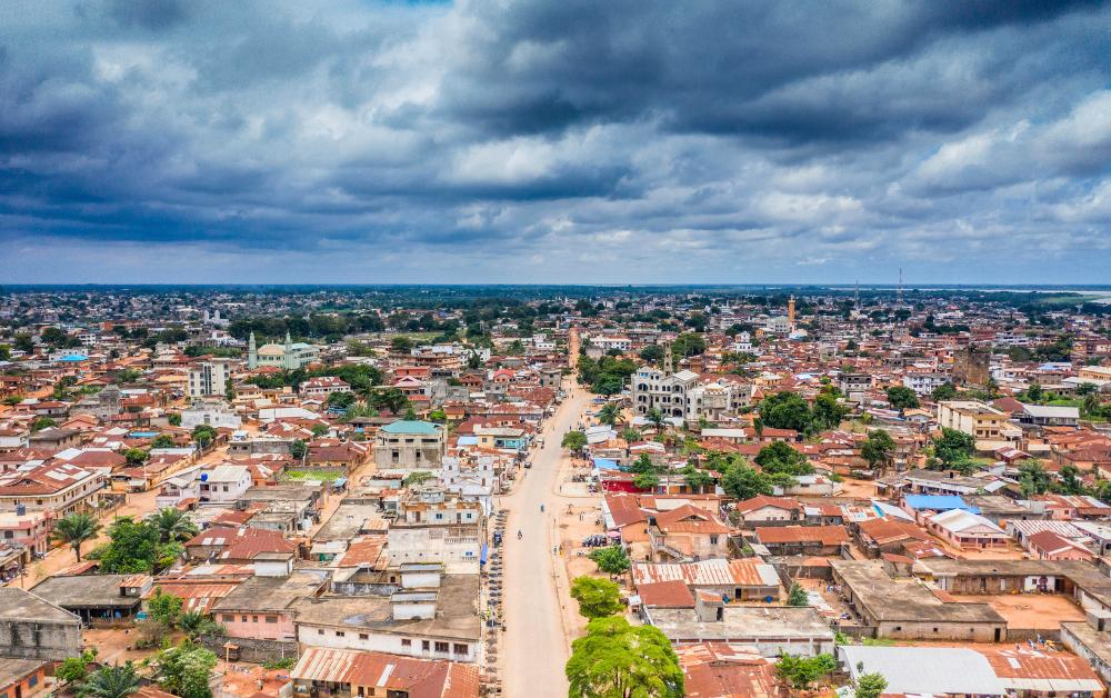 Luftaufnahme von Porto-Novo, der Hauptstadt Benins, mit dichtem Häusermeer und bewölktem Himmel