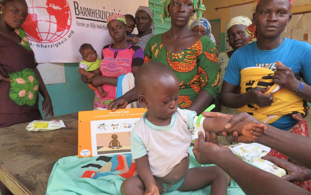 Mutter mit Kleinkind bei einer Ernährungsberatung von Barmherzigkeit International – Hilfe für unterernährte Kinder.