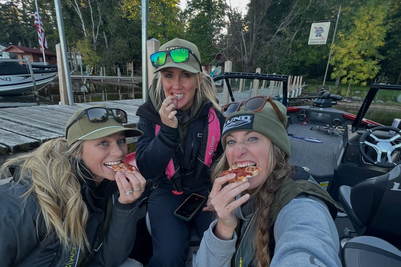 Three women eating pizza during a lunch break on the boat
