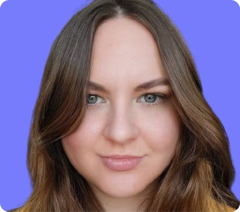 Close-up portrait of a woman with light skin, long brown hair, and blue eyes against a purple background.