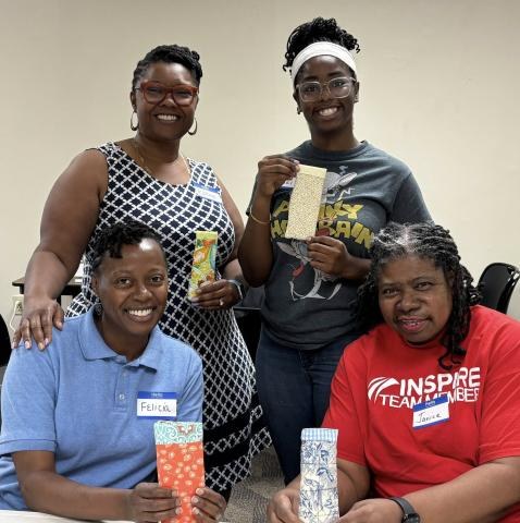 Four women pose for the camera with the eyeglasses cases they just made at the Cherokee Sewing Club.