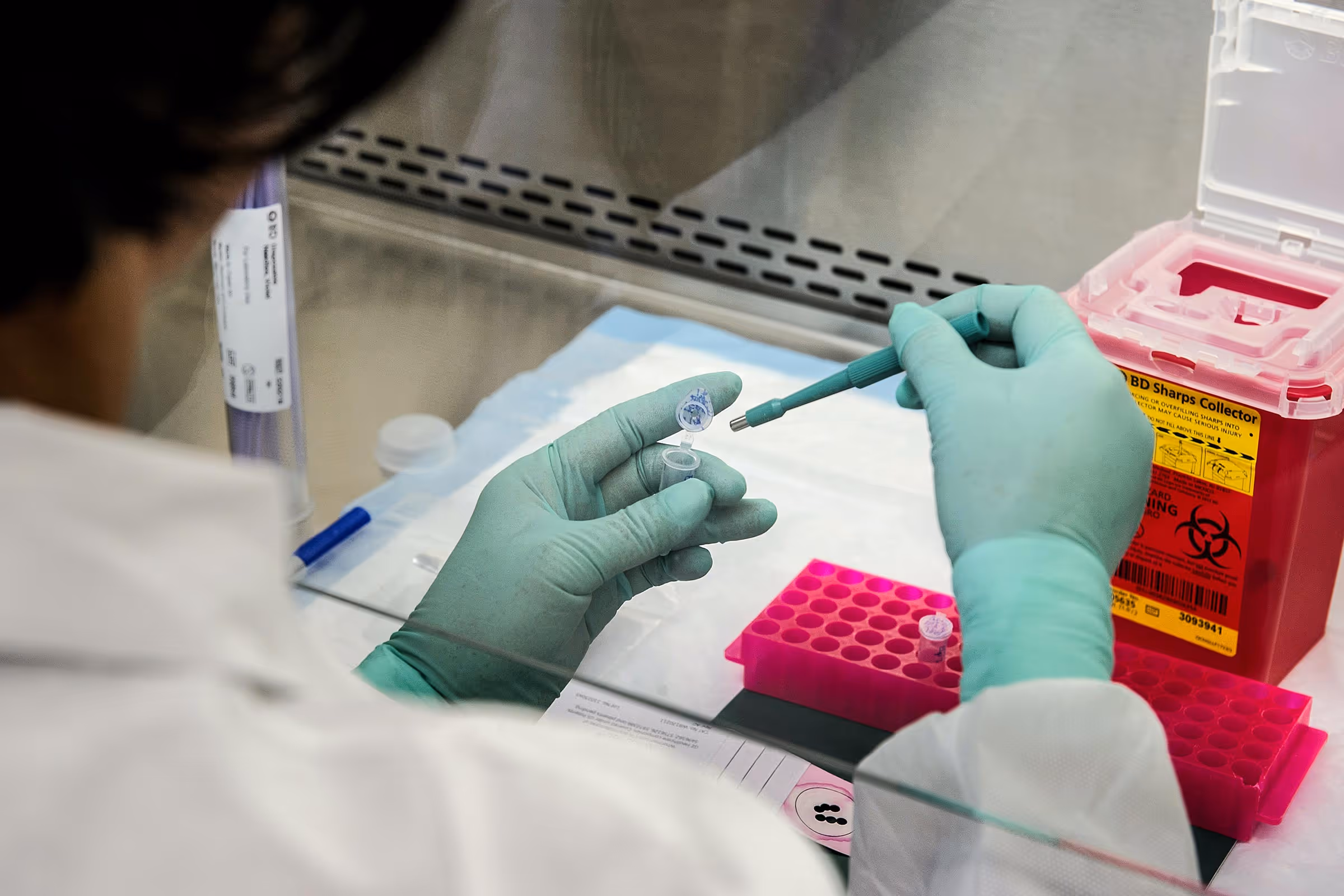A scientist working with samples in a test tube.