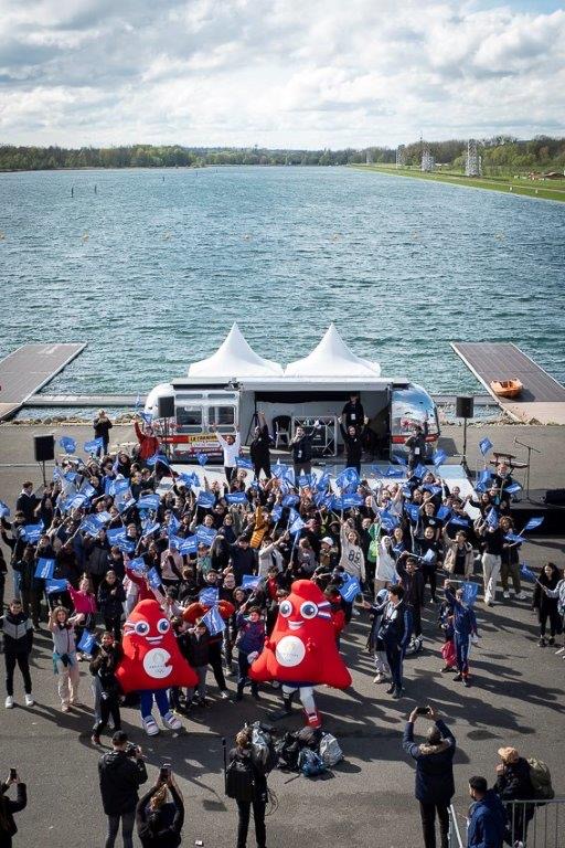 Grand événement en plein air au bord d'un plan d'eau, avec mascottes et public