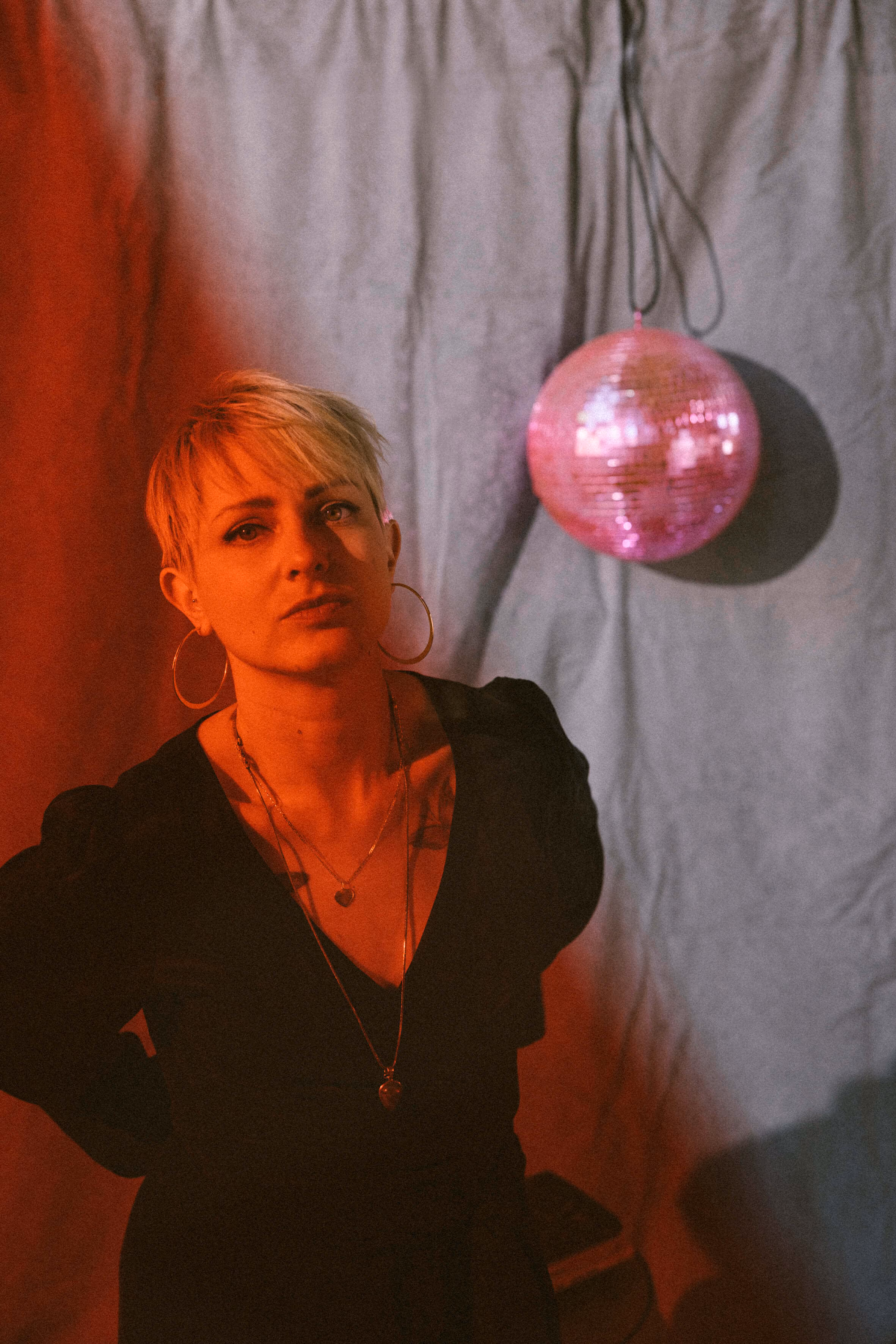 Portrait von Bianca mit einer rosa Discokugel im Hintergrund.