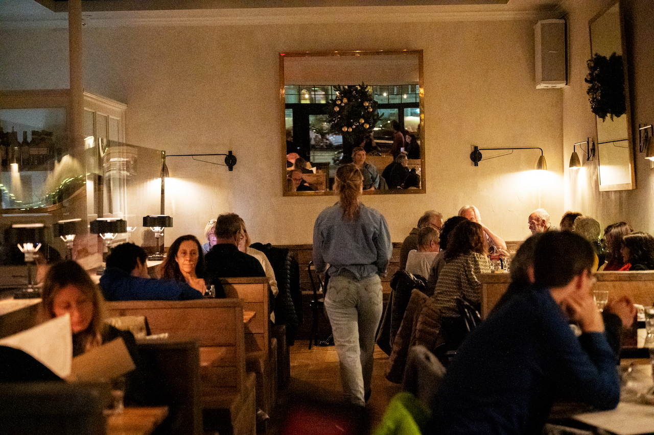 Guests at tables in the dining room on a busy night.