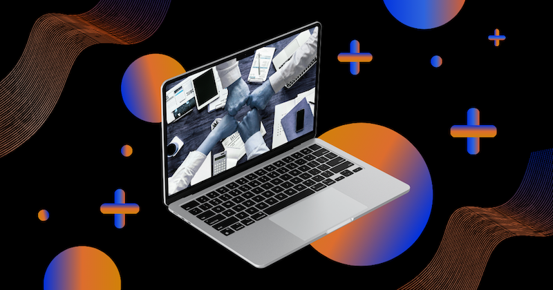 Laptop displaying a black-and-white image of multiple hands fist-bumping over a cluttered desk, symbolizing teamwork and collaboration