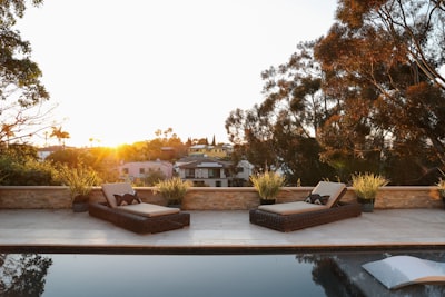 Outdoor pool with two lounge chairs.
