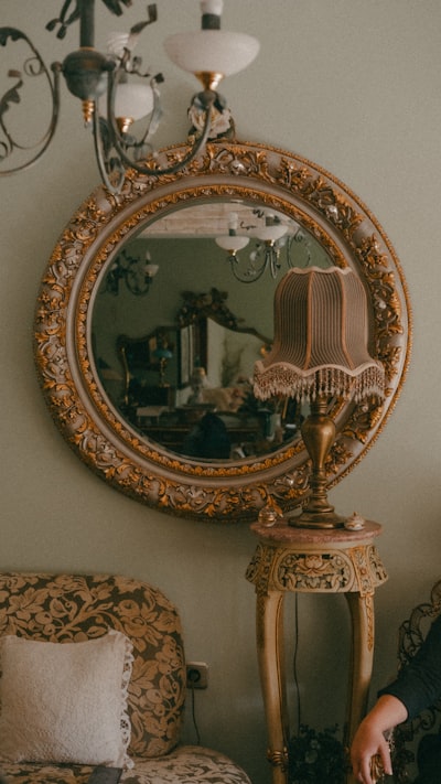 Ornate mirror above vintage pedastal.
