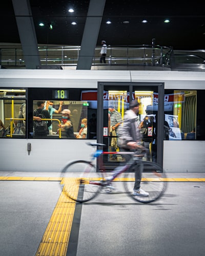 Blurred biker in front of a subway train.