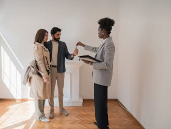 Real Estate Agent handing two people keys.