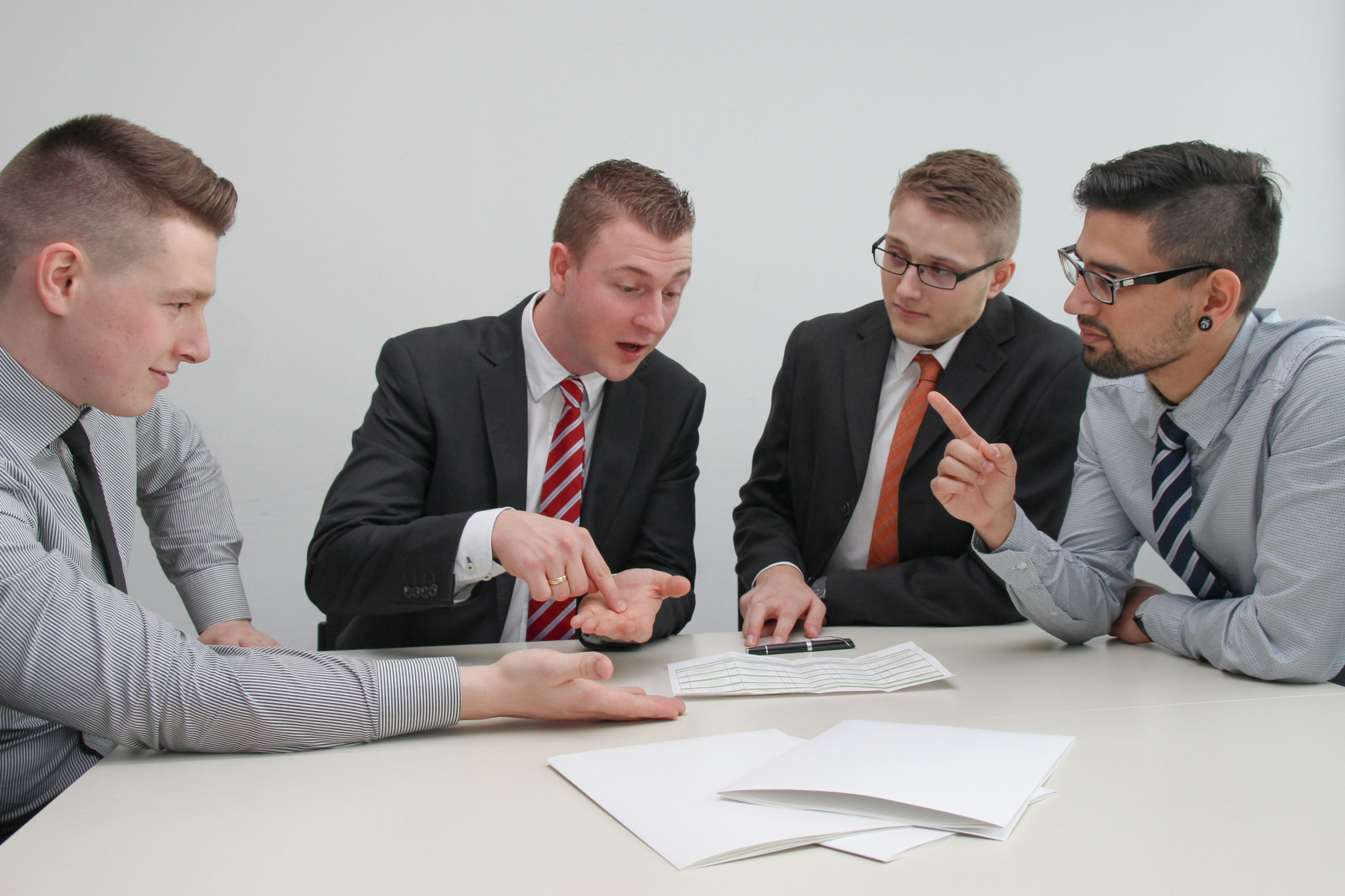 Group of men signing contracts. 