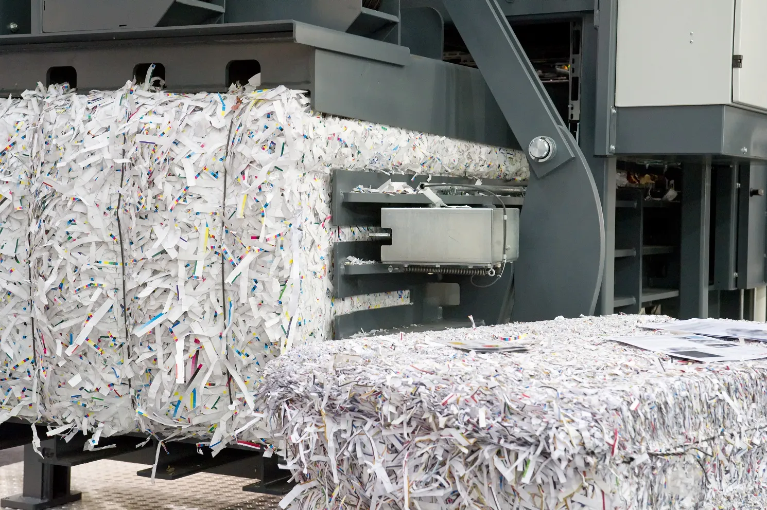 A paper shredding machine processing documents into shredded paper fragments.