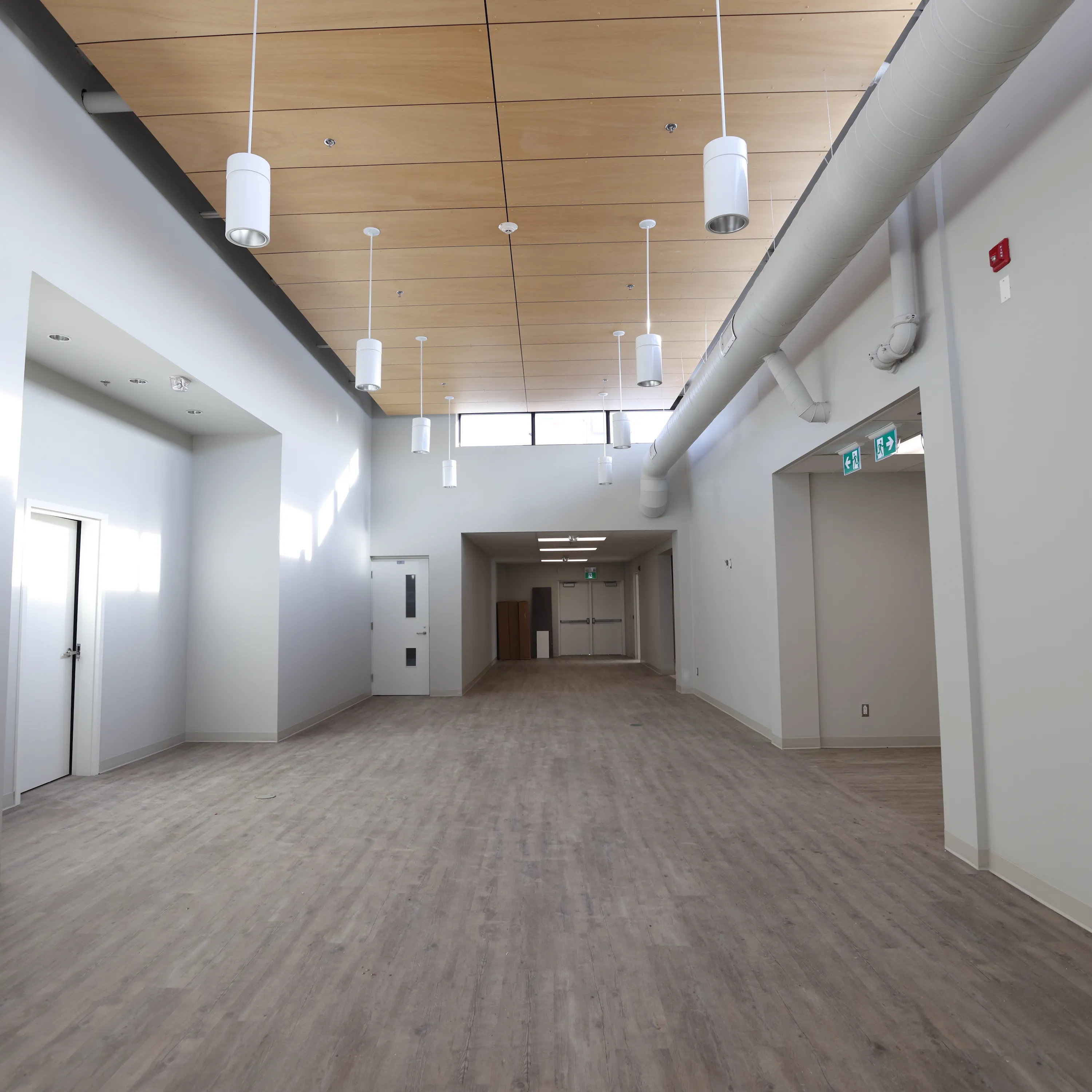 Renovated community centre corridor with a wood slat ceiling