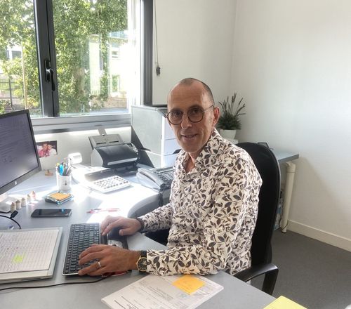 Un homme à son bureau tape sur son clavier d'ordinateur