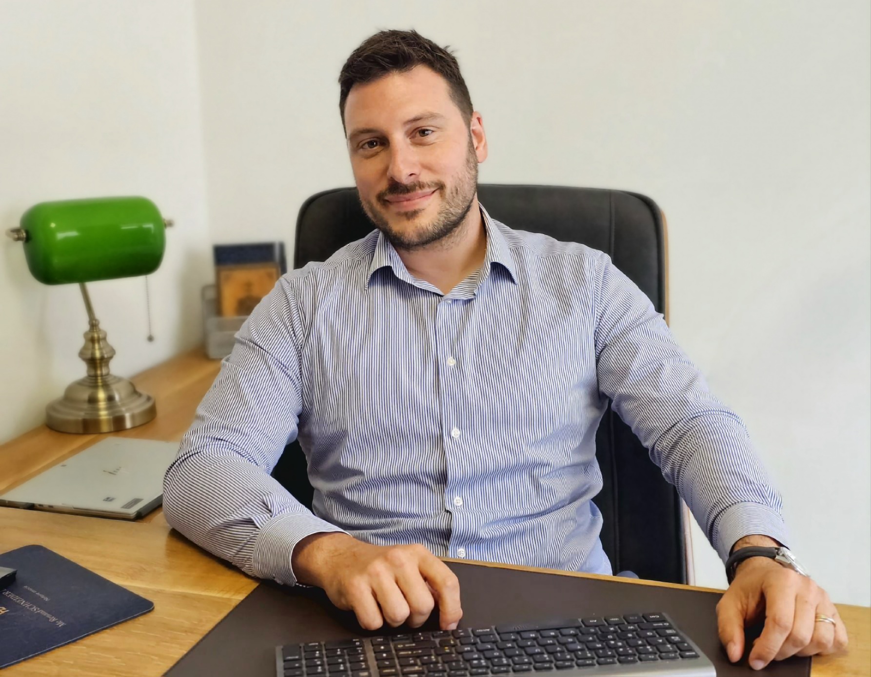 Un homme assis devant son clavier d'ordinateur