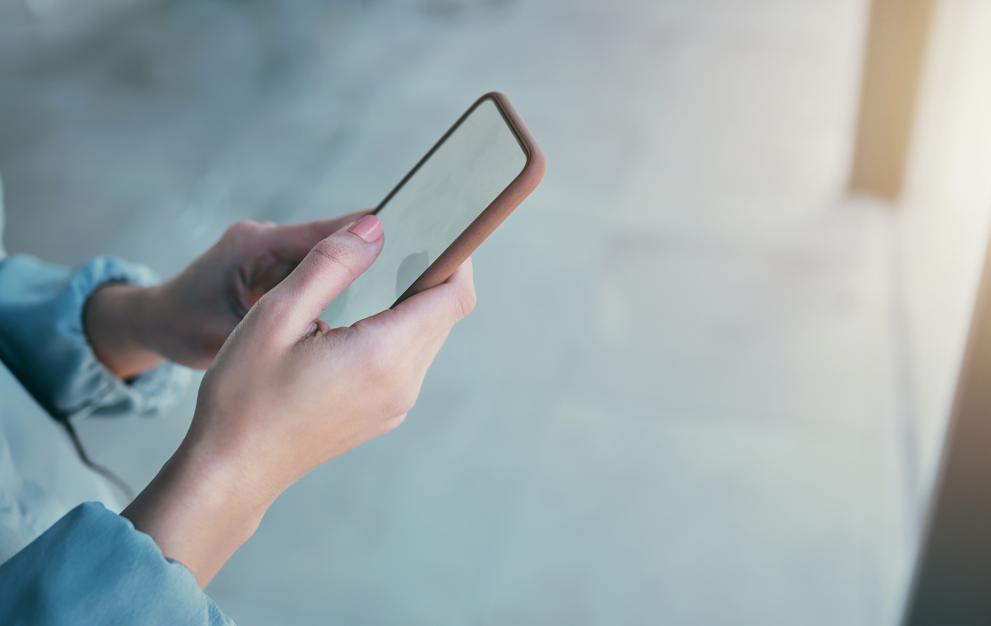 Personne consultant un smartphone, illustrant l’importance d’un site web hôtelier optimisé mobile pour augmenter les réservations en direct.