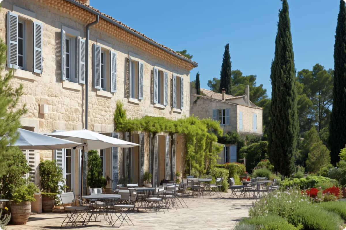 Hôtel resort de luxe en Provence avec terrasse extérieure, jardin paysager et bâtiment en pierre