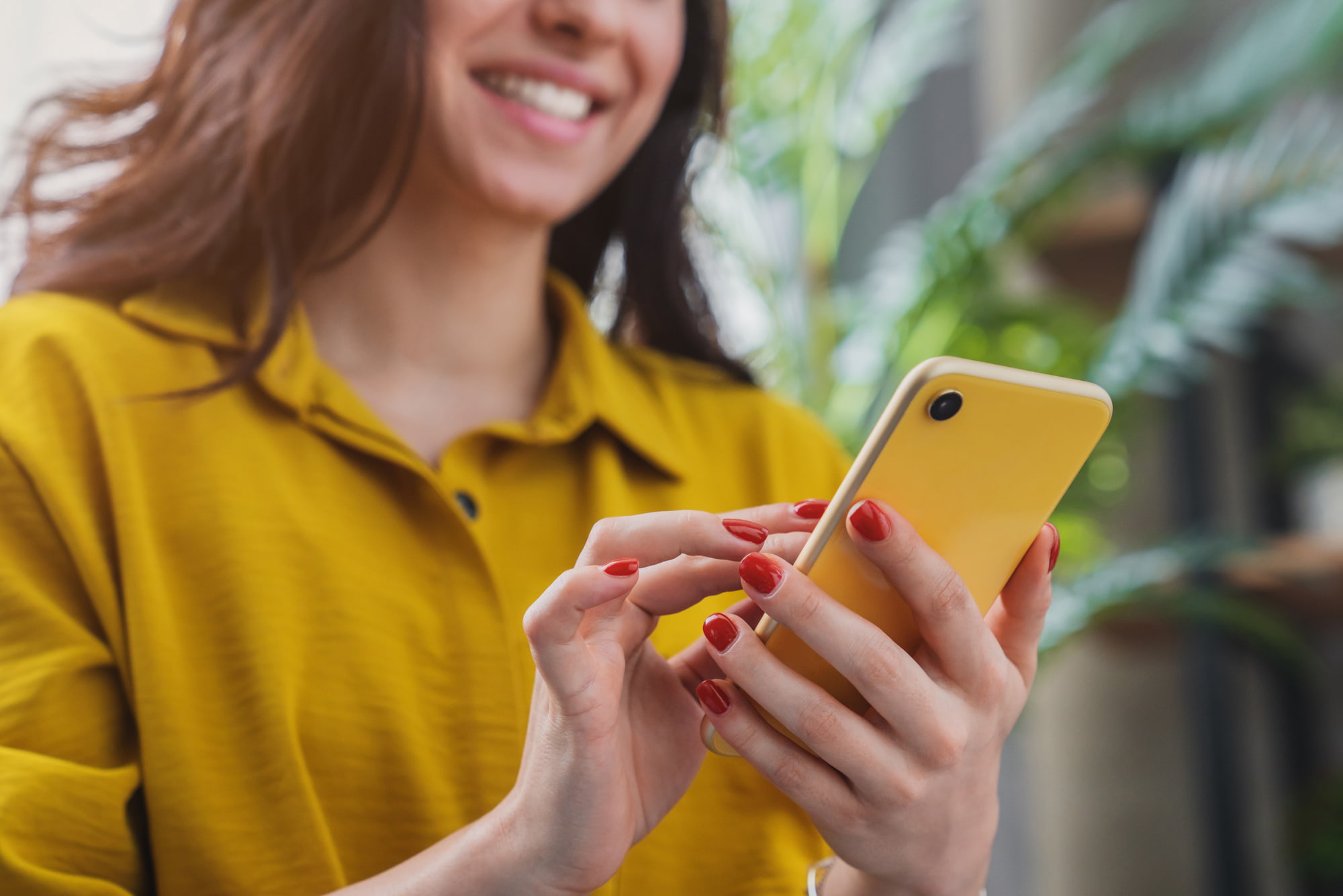 Cliente consultant des avis en ligne sur smartphone, illustrant la gestion de la e-réputation d’un hôtel