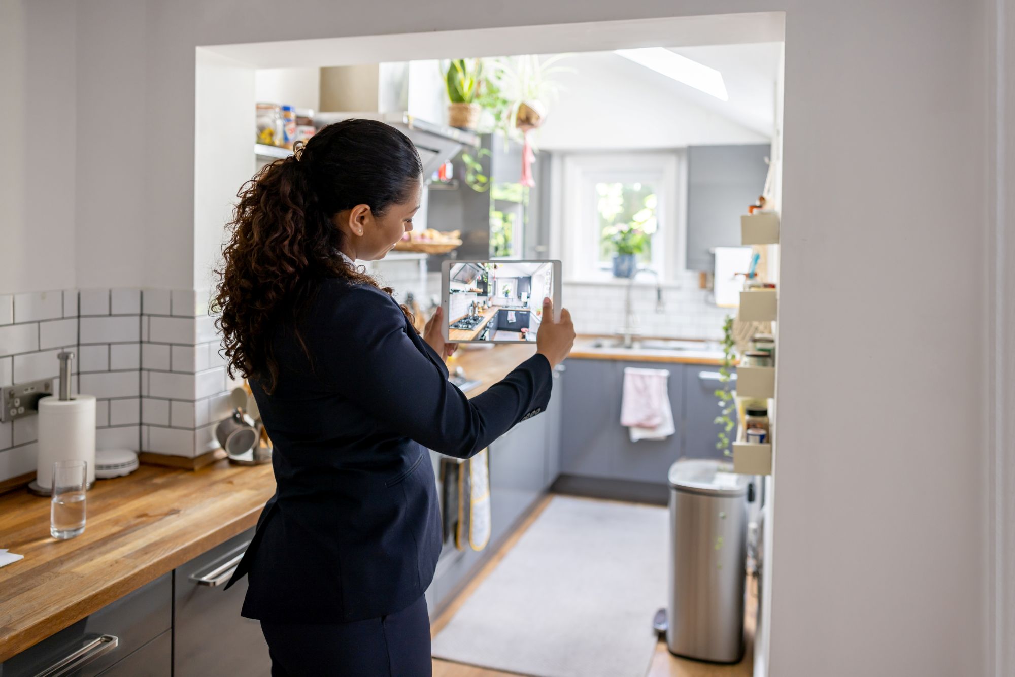 Une femme prend en photo une cuisine avec une tablette