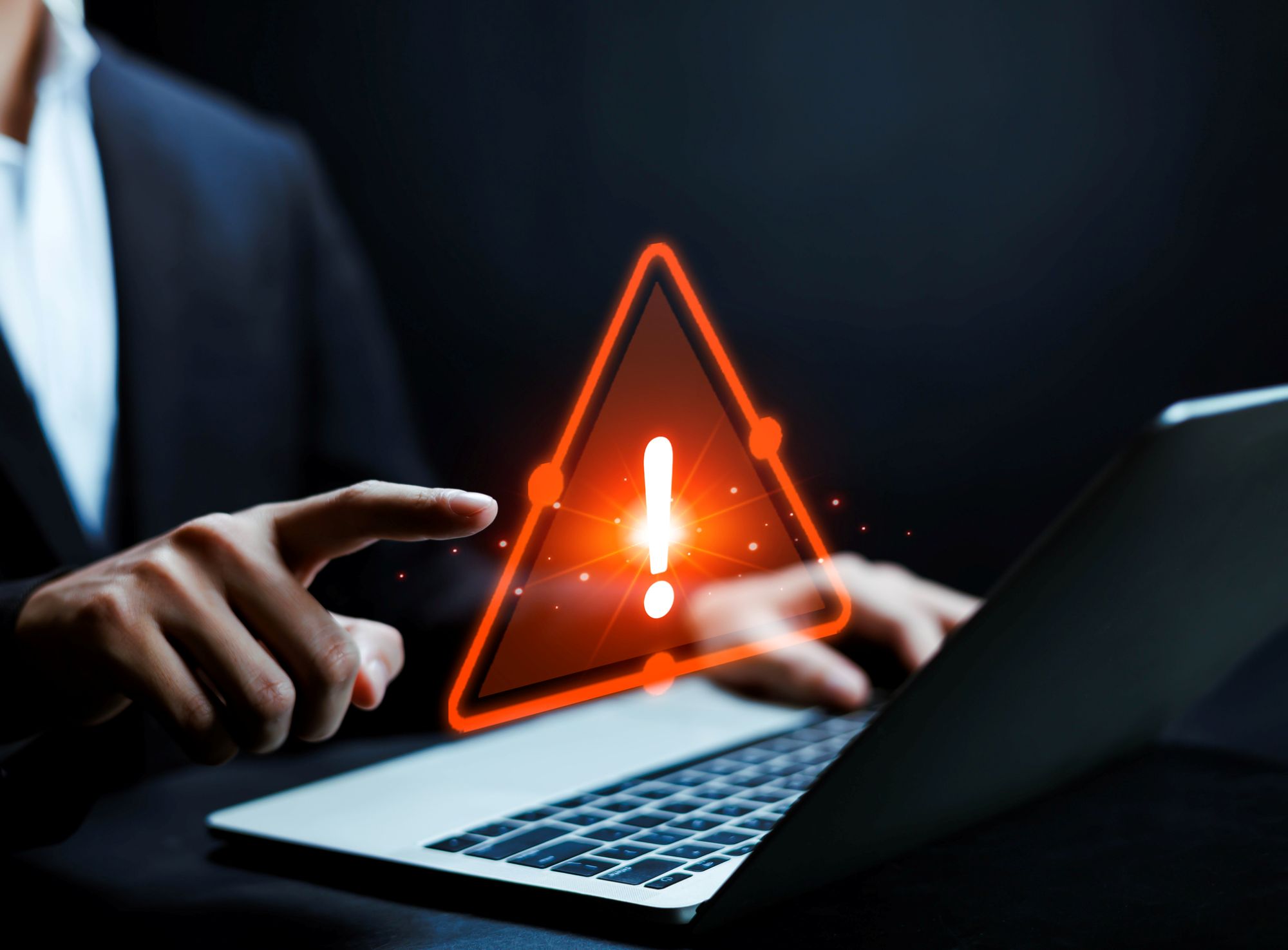 Un index pointé sur un triangle de sécurité rouge 