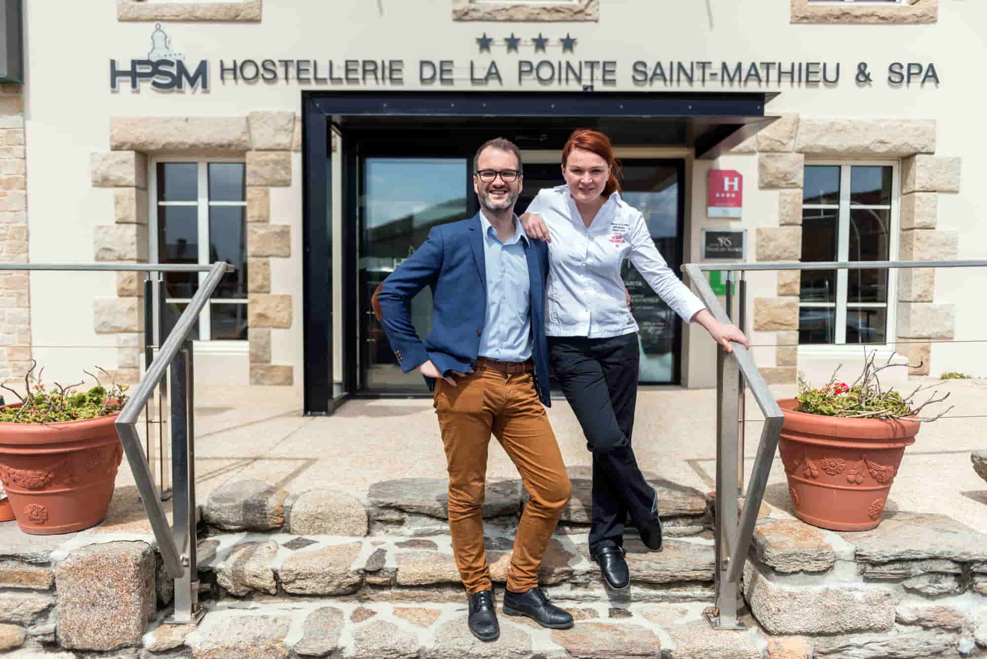 Le directeur et une collaboratrice posent devant l’Hostellerie de la Pointe Saint-Mathieu & Spa, établissement hôtelier multi-activités utilisant le PMS Asterio pour gérer hôtels, restaurants, spa et séminaires.