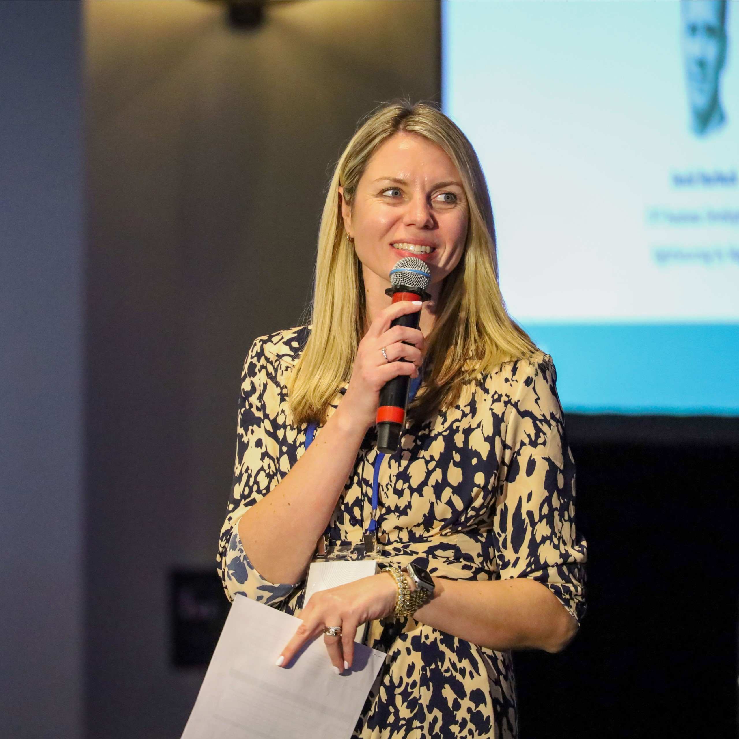 A speaker holding a microphone and notes during an IPMI session