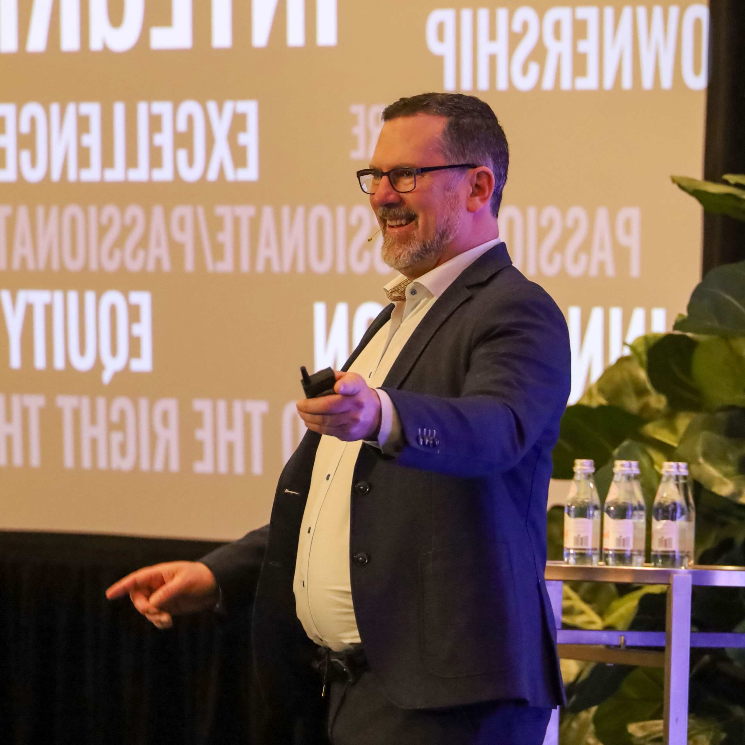 Speaker wearing a headset microphone and holding a presentation remote