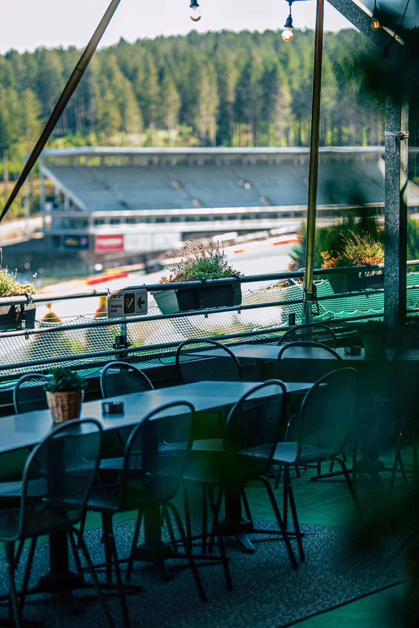 Tische und Stühle im Schutz einer großen Plane auf der Außenterrasse
