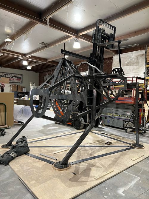 The bull's steel armature is standing in the middle of the Hotstrike shop, it's being supported by a forklift.