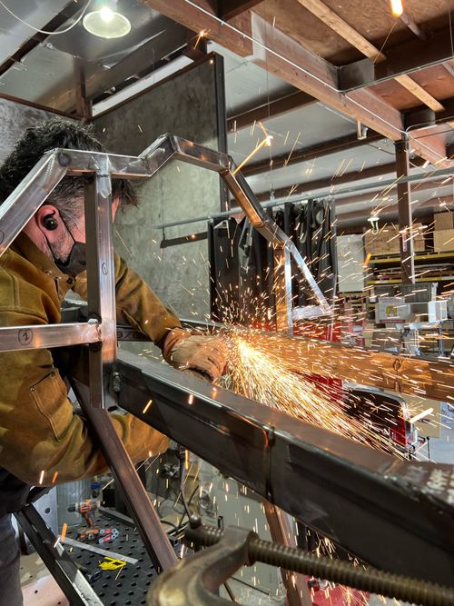 Golden sparks are flying as the bull armature's edges are ground down.
