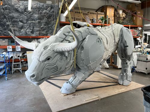 A large electronic bull statue standing ready to charge. It is assembled but unfinished and in the early stages of a fiberglass treatment.