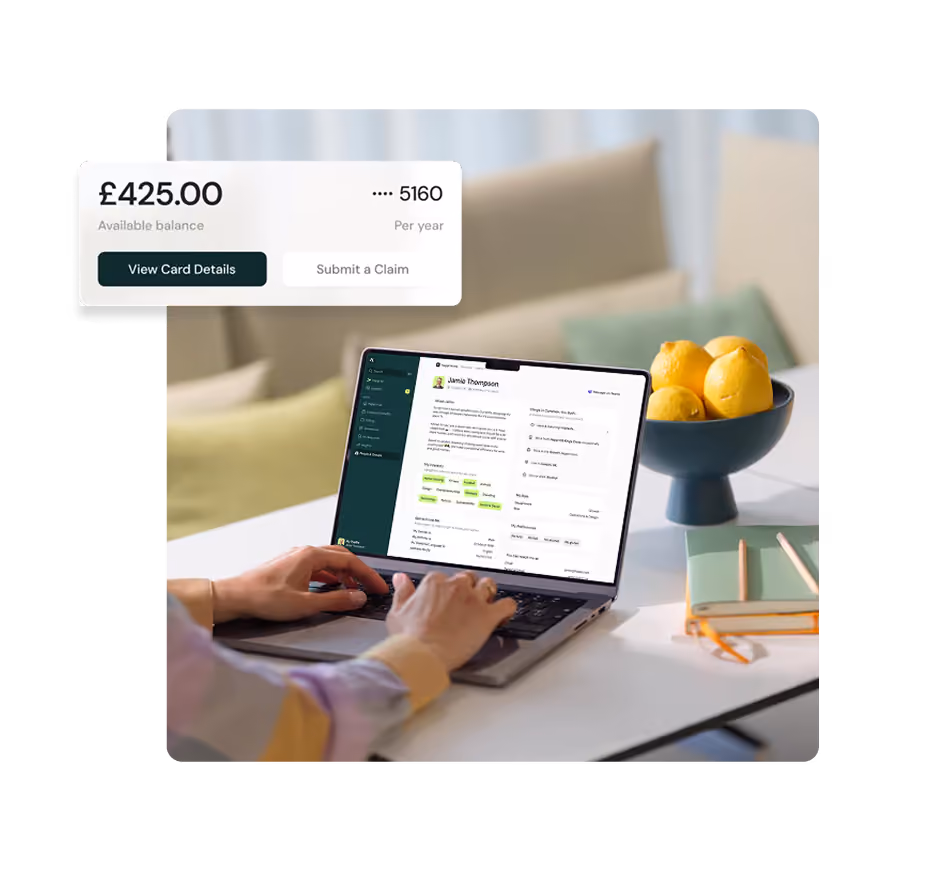 Person typing on a laptop displaying a user profile and summary interface for Jamie Thompson; on the left, a card showing £425.00 available balance per year with options to view card details or submit a claim; on the table, a bowl of lemons and stacked notebooks with pencils.
