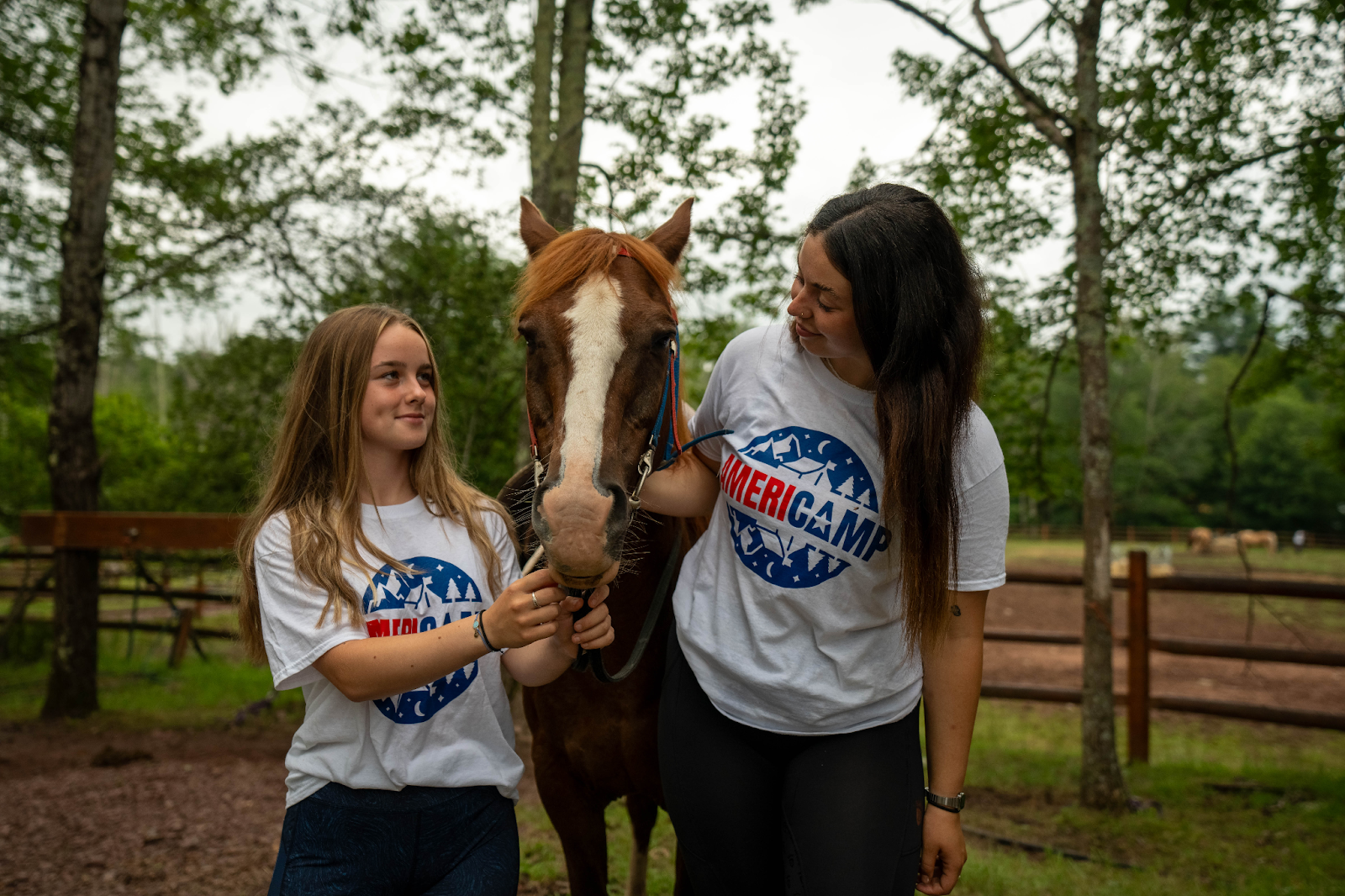 AmeriCamp counsellor and camper petting a horse