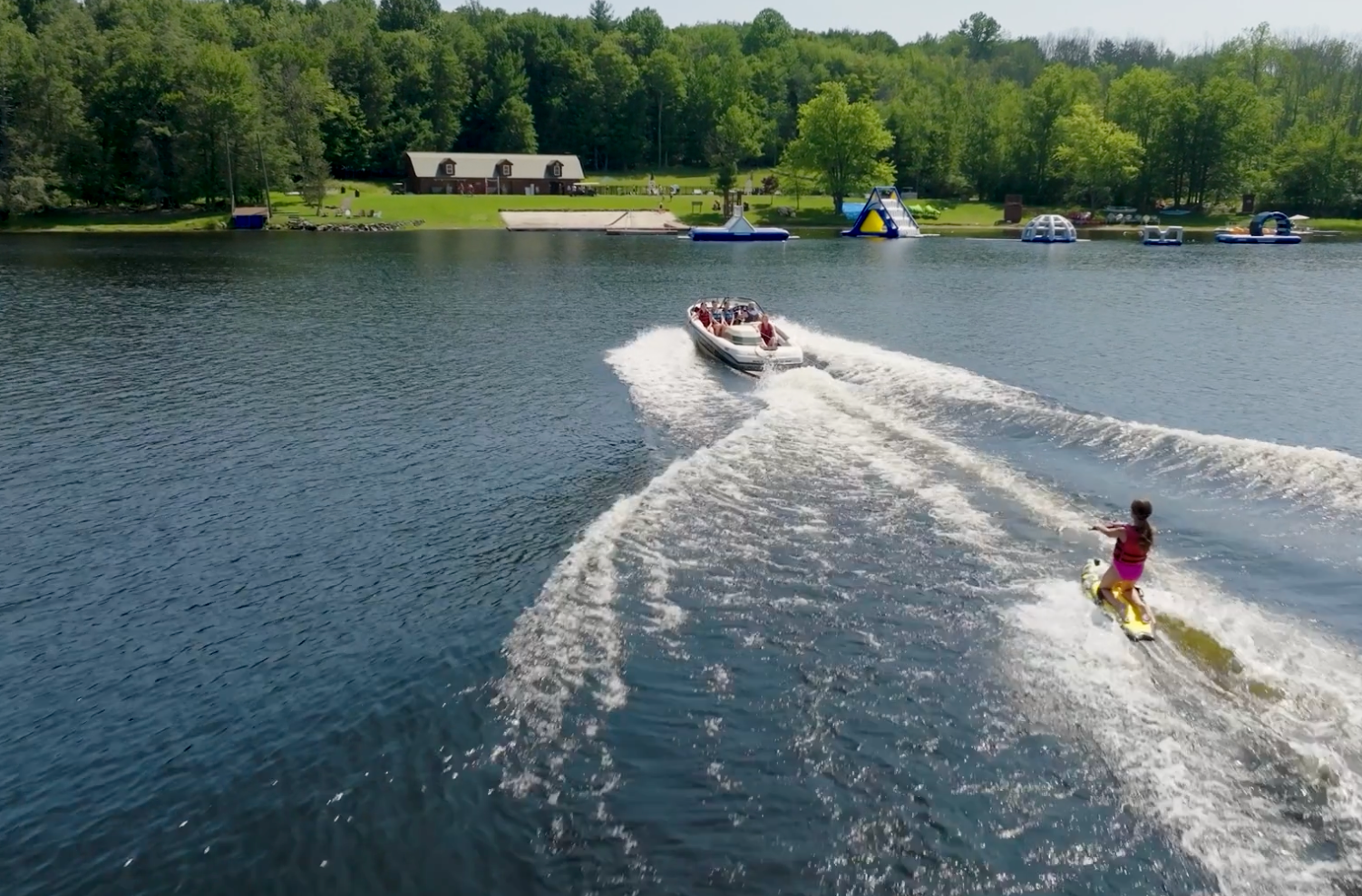 camp d'été au camp d'été faisant du kneeboard derrière un bateau sur un lac