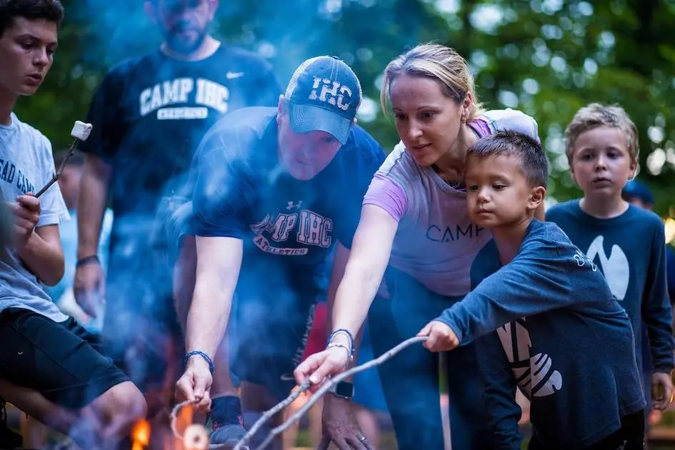 Camper und Betreuer im Camp IHC rösten Marshmallows über dem Lagerfeuer